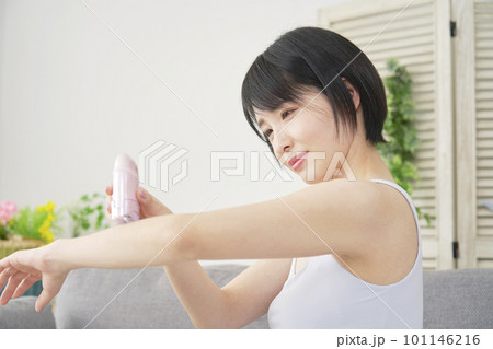 リビングで家庭用脱毛器で腕のセルフ脱毛をする女性 リビングで家庭用脱毛器で腕のセルフ脱毛をする女性 101146216