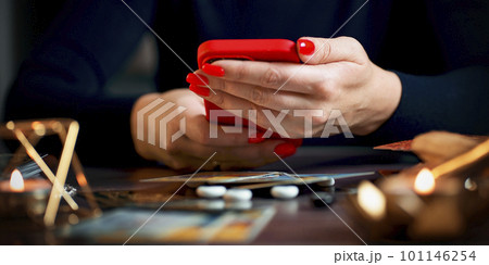 A fortune teller does online fortune telling on photos from a smartphone. 101146254