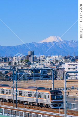 多摩川、丸子橋から見える雪化粧の富士山と東急電車 101147070