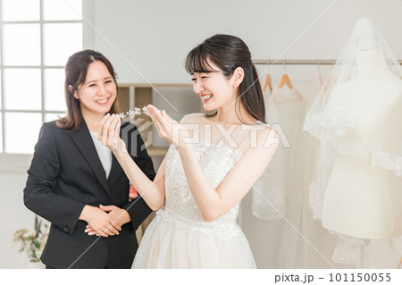 ヘッドドレス・髪飾りを選ぶウェディングドレスを着た花嫁とウェディングプランナーの女性 ヘッドドレス・髪飾りを選ぶウェディングドレスを着た花嫁とウェディングプランナーの女性 101150055
