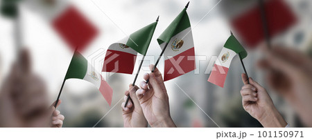 A group of people holding small flags of the Mexico in their hands 101150971