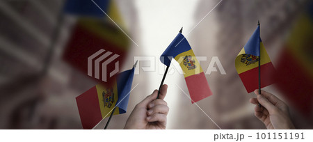 A group of people holding small flags of the Moldavia in their hands A group of people holding small flags of the Moldavia in their hands 101151191