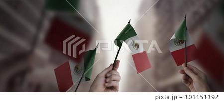 A group of people holding small flags of the Mexico in their hands A group of people holding small flags of the Mexico in their hands 101151192