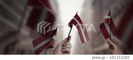 A group of people holding small flags of the Latvia in their hands 101151202