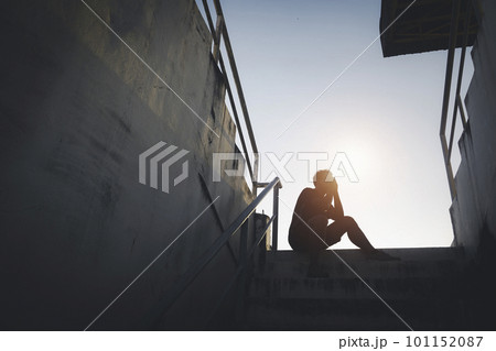 Silhouetted of sad photo. Lonely man sitting on the floor.He is unhappy and sad.He is depression.unlove,unhappy,fail.Photo concept for Disease and depression. 101152087