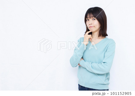 白い背景の前で腕組みをして悩んでいる30代の女性 白い背景の前で腕組みをして悩んでいる30代の女性 101152905