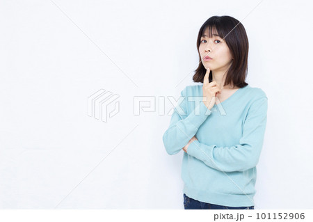 白い背景の前で腕組みをして悩んでいる30代の女性 白い背景の前で腕組みをして悩んでいる30代の女性 101152906