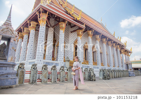 Young woman wearing Thai dress with accessories holding a bag at Wat Arun Ratchawararam It is a popular destination for tourists around the world. Bangkok, Thailand 101153218