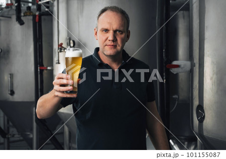 brewer at a brewery with glass of fresh beer brewer at a brewery with glass of fresh beer 101155087