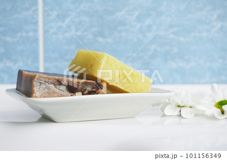 Close-up of organic craft soap bars with natural herbs ingredients and essential oils, on the soap holder against a blue marble bathroom wall background. Ecologically friendly cosmetic beauty products Close-up of organic craft soap bars with natural herbs ingredients and essential oils, on the soap holder against a blue marble bathroom wall background. Ecologically friendly cosmetic beauty products 101156349