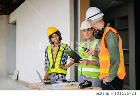 Engineers are discussing data working and laptop or tablet with architectural project at new construction site on big project. 101156721