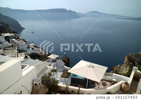 断崖絶壁の火山岩に建つ白い家並みとエーゲ海 101157493