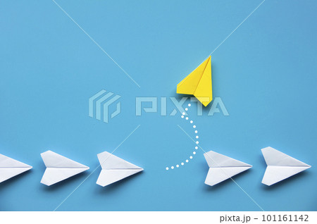 Yellow paper airplane origami leaving other white airplanes on blue background with customizable space for text or ideas. Leadership skills concept and copy space. Yellow paper airplane origami leaving other white airplanes on blue background with customizable space for text or ideas. Leadership skills concept and copy space. 101161142