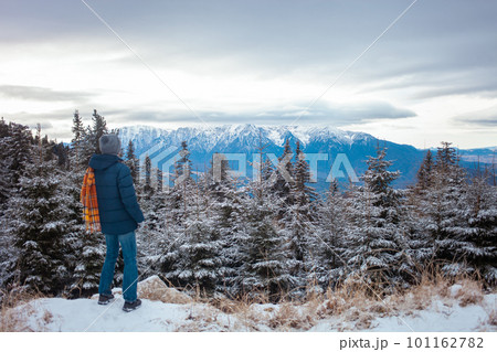 man looks at mountains, beautiful panorama, forest and sky, winter, snow, travel, resort, hiking, beauty of nature man looks at mountains, beautiful panorama, forest and sky, winter, snow, travel, resort, hiking, beauty of nature 101162782