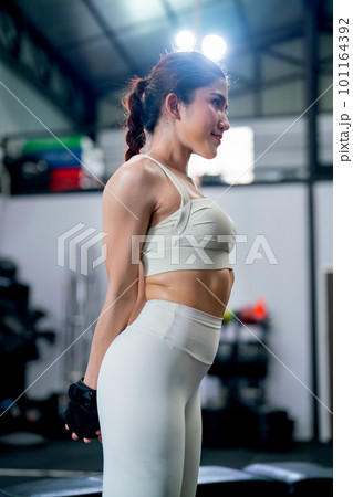Side view of Asian woman with sportwear stand with stretching action in fitness gym and relax 101164392