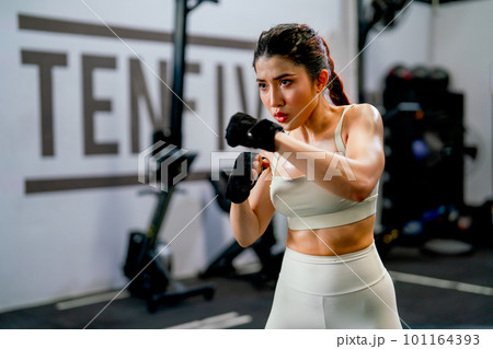 Asian woman action of boxing and training alone in fitness gym and she look concentrate to practice 101164393