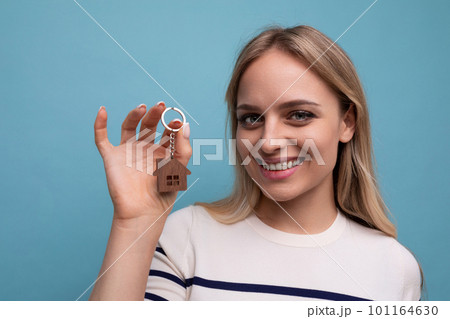 horizontal photo of a happy young woman who bought an apartment in a mortgage on a blue isolated 101164630