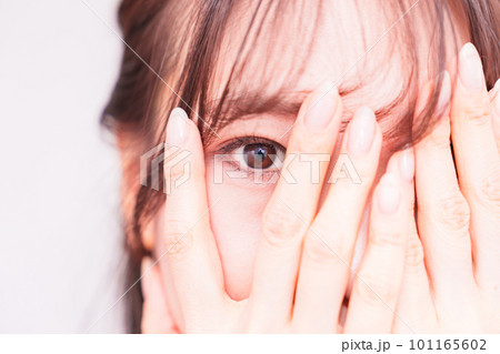 指の間 から 覗き見 をする 若い 女性 【 疑い の 眼差し の イメージ 】 指の間 から 覗き見 をする 若い 女性 【 疑い の 眼差し の イメージ 】 101165602