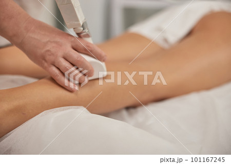 Correction cellulite, roller massage, figure correction. Young woman with body shaping machine, masseur massages client with vacuum roller, figure correction massage anti-cellulite massage 101167245