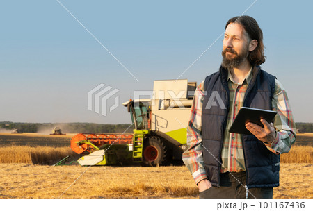Farmer with digital tablet on a background of harvester. Smart farming concept. 101167436