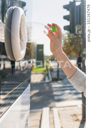 Woman uses a self service machine to receive used plastic bottles and cans on a city street 101167476