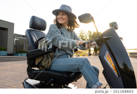 Woman tourist riding a four wheel mobility electric scooter Woman tourist riding a four wheel mobility electric scooter 101168603
