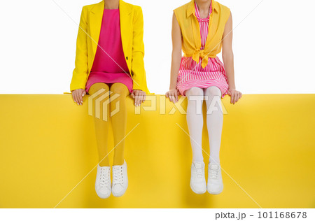 Women wearing bright tights sitting on color background, closeup 101168678