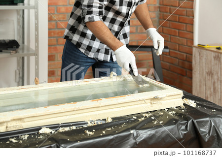 Man repairing old damaged window at table indoors, closeup 101168737