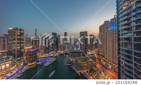 Aerial view to Dubai marina skyscrapers around canal with floating boats day to night timelapse Aerial view to Dubai marina skyscrapers around canal with floating boats day to night timelapse 101169266