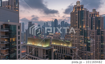 Dubai skyscrapers with golden sky over business bay district day to night timelapse. 101169482