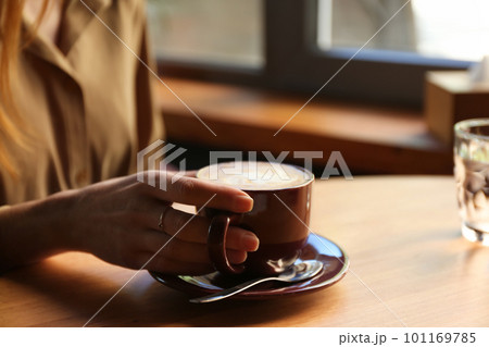 Woman with aromatic coffee at table in cafe, closeup Woman with aromatic coffee at table in cafe, closeup 101169785