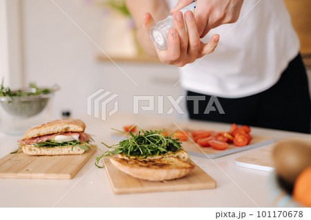 Man using salt grinder for preparing tasty sandwich at home. Middle selection  101170678