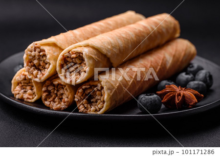 Delicious crispy wafer rolls with cream filling with nuts Delicious crispy wafer rolls with cream filling with nuts 101171286