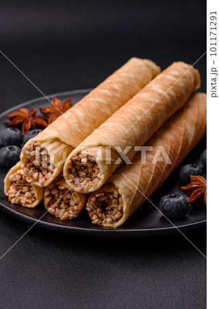 Delicious crispy wafer rolls with cream filling with nuts Delicious crispy wafer rolls with cream filling with nuts 101171291