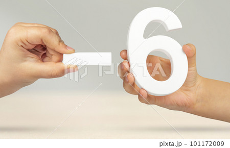 Minus six. The number six and the minus symbol in a hand close-up on a light gray background. The concept of removal or taking away 101172009