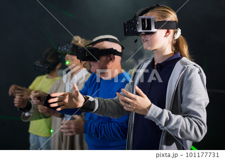 Girl in VR headset playing games with his family Girl in VR headset playing games with his family 101177731