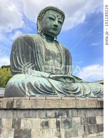 青空と雲の下の、左斜め前からの鎌倉の大仏様です。の写真素材
