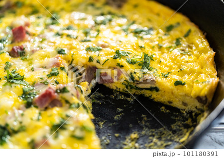 Freshly baked spinach and ham frittata in cast iron skillet. Freshly baked spinach and ham frittata in cast iron skillet. 101180391