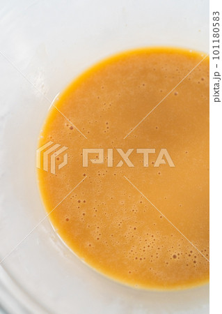 Mixing ingredients with a hand mixer in a small mixing bowl to make the eggnog caramel sauce. Mixing ingredients with a hand mixer in a small mixing bowl to make the eggnog caramel sauce. 101180583