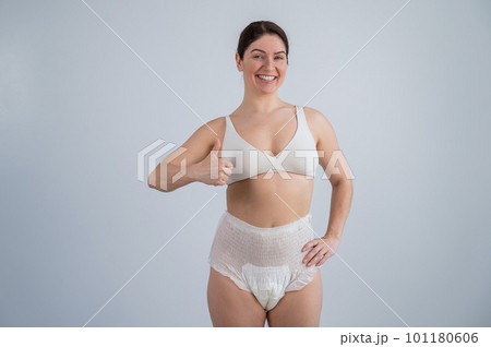 Woman in adult diapers smiling and showing thumbs up. Urinary incontinence problem. Woman in adult diapers smiling and showing thumbs up. Urinary incontinence problem. 101180606