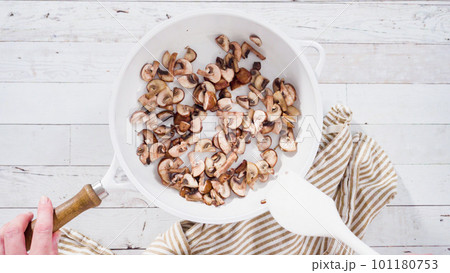 Flat lay. Sauteed organic baby bella mushrooms in a white frying pan. Flat lay. Sauteed organic baby bella mushrooms in a white frying pan. 101180753