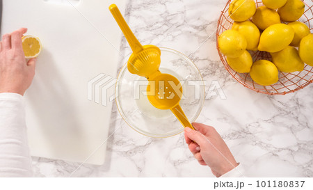 Flat lay. Step by step. Squeezing fresh lemon juice into a small glass mixing bowl. Flat lay. Step by step. Squeezing fresh lemon juice into a small glass mixing bowl. 101180837