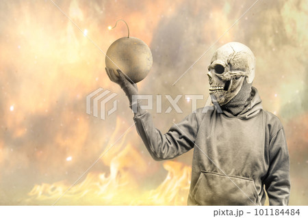 A man wearing a mask standing while holding a ball bomb 101184484