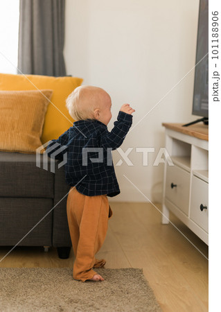 Caucasian baby newborn infant making first steps. Cute toddler kid child son boy learning walking creeping on living room. Childcare and childhood concept 101188906