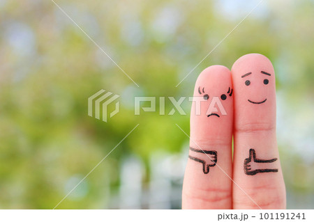 Fingers art of couple. Woman showing thumb down and man showing thumb up. Concept of disagreement in family. 101191241