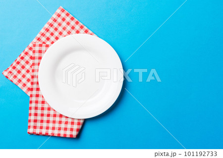 Top view on colored background empty round white plate on tablecloth for food. Empty dish on napkin with space for your design 101192733