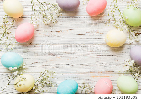 Happy Easter composition. Easter eggs on colored table with gypsophila. Natural dyed colorful eggs background top view with copy space 101193309