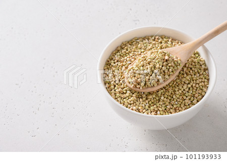 Raw green buckwheat in white bowl on white background. 101193933