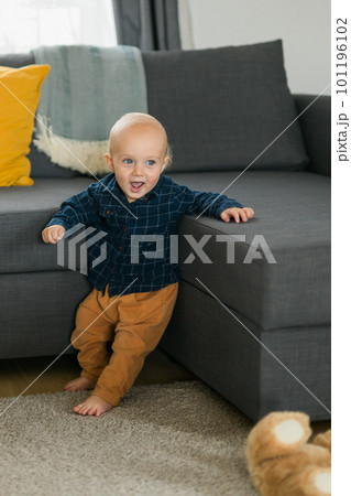 Caucasian baby newborn infant making first steps. Cute toddler kid child son boy learning walking creeping on living room copy space. Childcare and childhood concept Caucasian baby newborn infant making first steps. Cute toddler kid child son boy learning walking creeping on living room copy space. Childcare and childhood concept 101196102