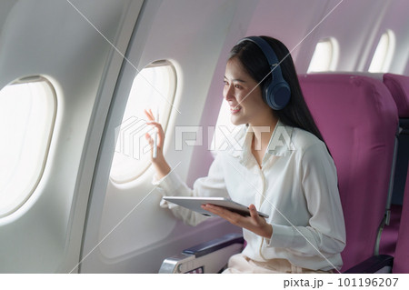 Beautiful Asian businesswoman working with digital tablet in aeroplane. working, travel, business concept Beautiful Asian businesswoman working with digital tablet in aeroplane. working, travel, business concept 101196207